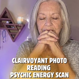 Peut inclure: Une personne aux cheveux gris, les yeux fermés, les mains jointes, portant un haut gris texturé. Le texte superposé indique : CLAIRVOYANT PHOTO READING PSYCHIC ENERGY SCAN. Une bougie allumée dans un pot en verre et un jeu de cartes sont visibles.