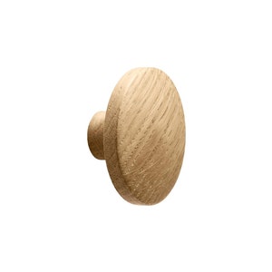 May include: A round wooden knob with a light brown finish. The knob has a slightly raised edge and a smooth surface.