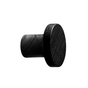 May include: A black wooden wall hook featuring a cylindrical base and a circular, flat head. The wood grain is visible on the surface. Suitable for hanging items in a home or office.
