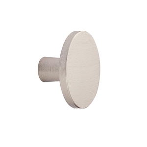 May include: A brushed nickel oval cabinet knob. The knob has a cylindrical base and a flat, oval-shaped head. The metal has a matte finish and a subtle, textured appearance. Suitable for drawers and cabinets.