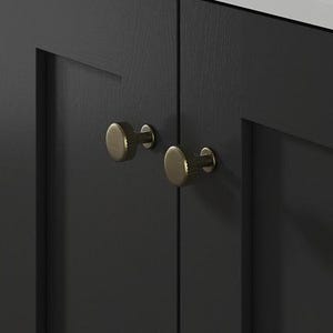 May include: A close-up of a dark grey cabinet with gold-coloured knobs. The cabinet doors have a recessed panel design. A white countertop with subtle grey veining is above the cabinet.