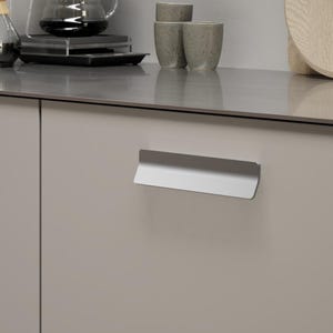 May include: A contemporary kitchen scene in neutral tones. It showcases a coffee brewing station with a glass carafe, a pour-over device, and ceramic mugs. The cabinets have stylish, silver handles.