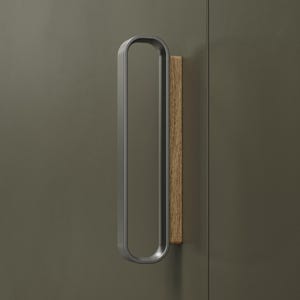 May include: A contemporary cabinet pull featuring a rounded, matte grey handle and a rectangular, light-brown wooden accent. The handle is mounted on a dark green surface, offering a minimalist aesthetic.