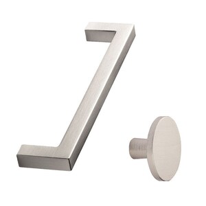 May include: A brushed nickel cabinet pull with a rectangular shape and a rounded knob. The pull is angled and the knob is round.