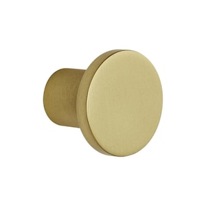 May include: A gold-coloured cabinet knob with a cylindrical body and a flat, circular face. The knob has a simple, modern design and is likely made of metal. The finish appears to be brushed or matte, giving it a subtle sheen.