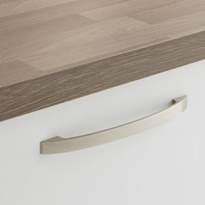 May include: A brushed nickel cabinet pull with a curved design. The pull is mounted on a white cabinet door.