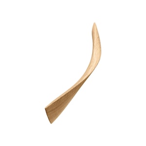 May include: A light brown wooden cabinet pull with a curved design.