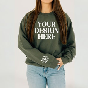 May include: A dark green sweatshirt with the text "YOUR DESIGN HERE" on the front and the same text on the left sleeve.