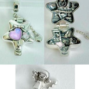 May include: A silver-toned star-shaped locket charm featuring a pink heart and a small star inlay on the front. The locket opens to reveal intricate interior detailing. A separate small silver-toned figurine of a winged character is also shown.