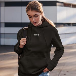 Peut inclure: Un sweat à capuche noir avec un texte brodé blanc qui dit "BASIC AF."