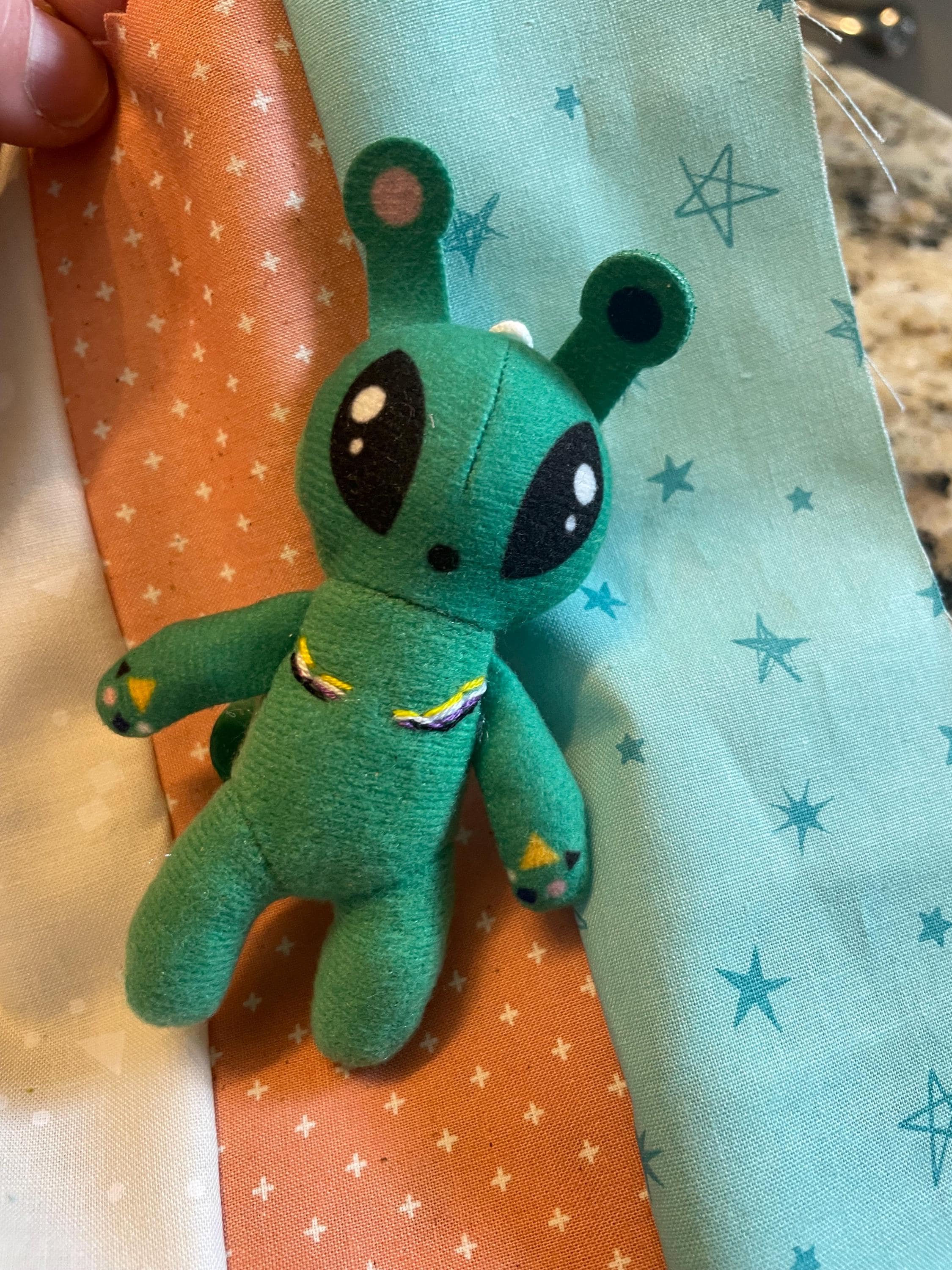 Tiny Alien with Top Surgery Scars in trans flag colors