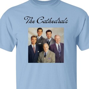May include: Light blue t-shirt with a picture of a band called "The Cathedrals". The band is made up of five men wearing suits and ties.