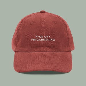 Op de afbeelding: Roodbruine corduroy baseballcap met een gebogen klep. De cap heeft de tekst "F*ck Off I'm Gardening" in witte letters. De pet heeft een ronde bovenkant en een verstelbare band.