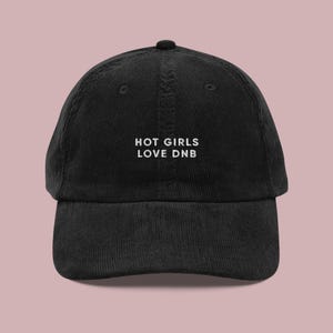 Puede incluir: Gorra de béisbol de pana negra con texto bordado en blanco que dice "HOT GIRLS LOVE DNB".