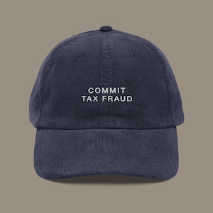 Puede incluir: Una gorra de béisbol de pana azul marino con texto blanco bordado que dice "COMMIT TAX FRAUD".