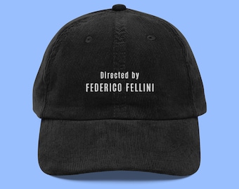 Może przedstawiać: Czarna bejsbolówka z cordu z białym haftem "Directed by FEDERICO FELLINI".