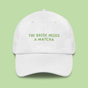 May include: White baseball cap with the text "THE BRIDE NEEDS A MATCHA" in green. The cap has a curved brim and a classic six-panel design, perfect for casual wear or a bachelorette party.