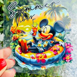 May include: A clear sticker featuring Mickey Mouse wearing a blue floral shirt, relaxing in a yellow inflatable pool ring on water. He holds a drink with a lime slice. The background shows palm trees and a sunset. The text Summer Vibes is printed above.