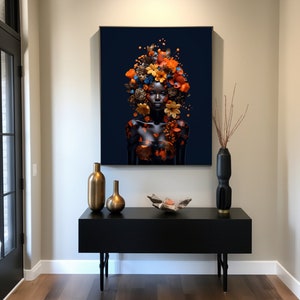 Peut inclure: Un portrait en noir et blanc d'une personne avec une couronne de fleurs orange, brunes et bleues sur la t&ecirc;te. Le portrait est accroch&eacute; au mur au-dessus d'une console noire avec deux vases dor&eacute;s et un objet d&eacute;coratif.