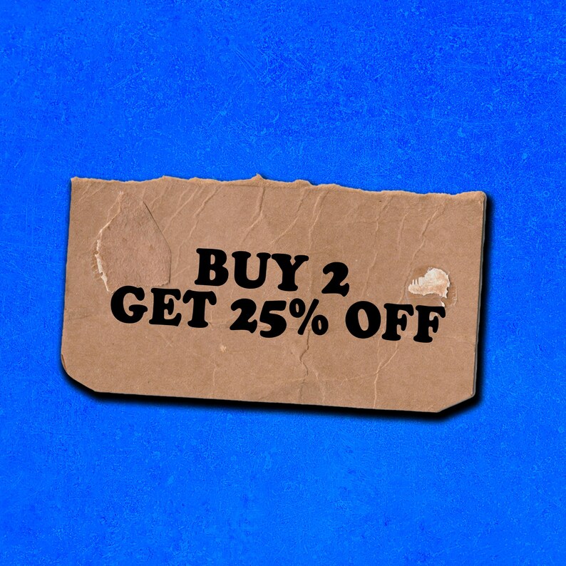 May include: A brown paper tag with torn edges, advertising a sale. The text reads "BUY 2 GET 25% OFF" in black letters.