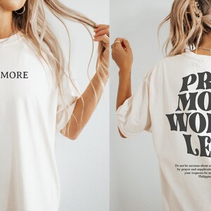 Puede incluir: Camiseta blanca con el texto "Pray More" en la parte delantera y "Pray More Worry Less" en la parte trasera. La parte trasera tambi&eacute;n incluye una cita de Filipenses 4:6-7.