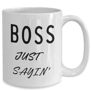 May include: White ceramic coffee mug with black text that reads "BOSS JUST SAYIN'"