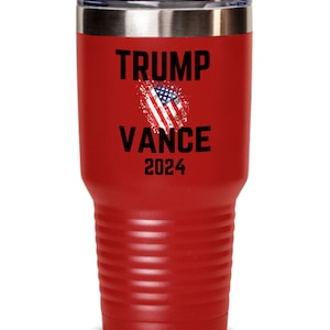 May include: Red stainless steel tumbler with a black and white American flag graphic and the text "TRUMP VANCE 2024".