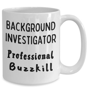 May include: White ceramic coffee mug with black text that reads "Background Investigator Professional Buzzkill".