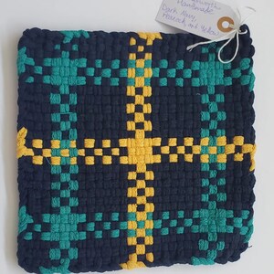 May include: Handmade woven pot holder with a checkered pattern in dark navy, teal, and yellow.