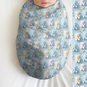 May include: A baby swaddled in a light blue blanket patterned with small teddy bears in pastel colors and yellow flowers. The blanket is wrapped around the baby, with a matching pattern visible on the side.