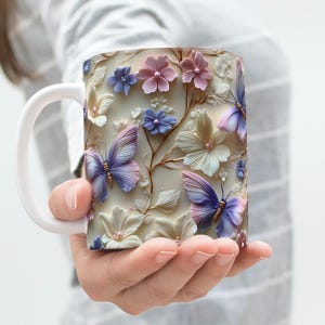 May include: White ceramic mug with a floral design featuring pink, purple, and blue butterflies and flowers.