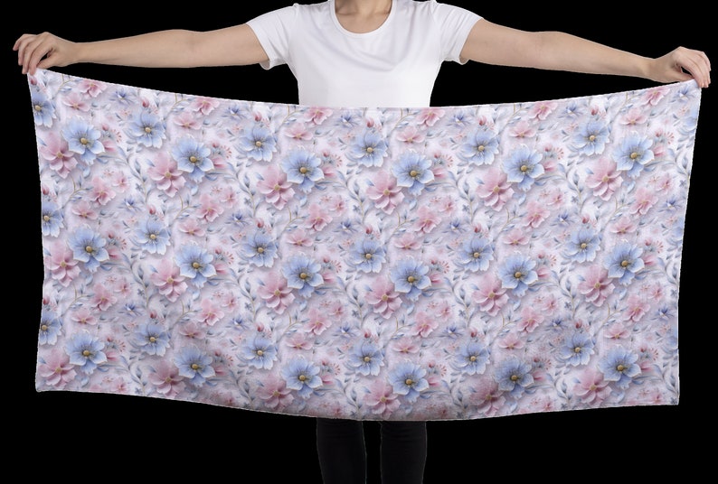 May include: A white fabric scarf with a repeating pattern of pink and blue flowers. The flowers are stylized and have a 3D effect.