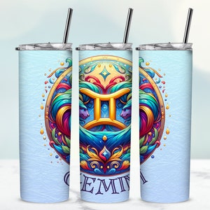 Puede incluir: Un vaso de acero inoxidable con un colorido diseño del signo zodiacal Géminis. El diseño presenta un símbolo dorado de Géminis, dos figuras estilizadas y la palabra "GEMINI" en una fuente decorativa. El vaso tiene una tapa plateada y una pajita a juego.