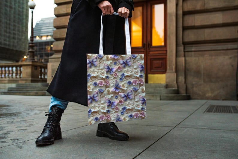 May include: A white tote bag with a floral pattern featuring purple butterflies and pink flowers. The bag has white handles.