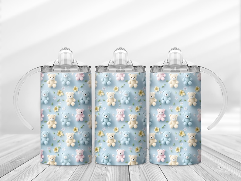 May include: Three baby sippy cups with a light blue background. The cups are decorated with a pattern of teddy bears in pastel colors and small yellow flowers. Each cup has a clear lid and handles.