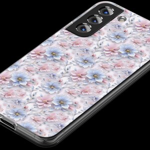 May include: A clear phone case with a floral design featuring pink and blue flowers on a white background. The case has a raised camera bump with three black camera lenses.
