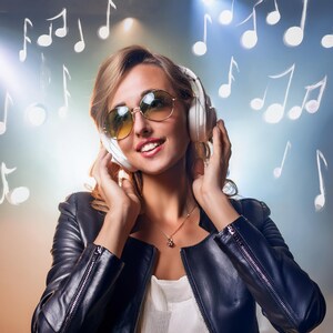 以下が含まれることがあります： 黒い革のジャケットとサングラスをかけた女性が、白いヘッドホンで音楽を聴いています。彼女は笑顔で、ブロンドの髪をしています。