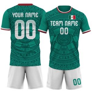 Op de afbeelding: Een groen voetbalshirt en short set met witte accenten. Het shirt toont de Mexicaanse vlag, de tekst "TEAM NAME" en het nummer "00". De achterkant van het shirt heeft de tekst "YOUR NAME" en het nummer "00". Het shirt heeft een gedetailleerd Azteeks patroon.