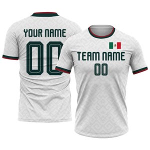 Op de afbeelding: Wit voetbalshirt met groene en rode accenten. Het shirt toont de Mexicaanse vlag, de tekst "TEAM NAME" en het nummer "00" op de voorkant. De achterkant van het shirt heeft de tekst "YOUR NAME" en het nummer "00".