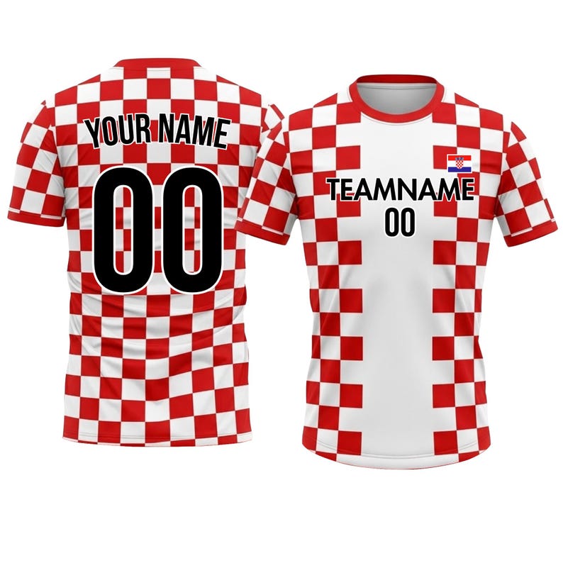 以下が含まれることがあります： 2つの半袖サッカーユニフォーム。1つは、背中と袖に赤と白のチェック柄があり、「YOUR NAME」の文字と黒色の数字「00」がプリントされています。もう1つは、前面が白で「TEAMNAME」の文字と数字「00」がプリントされています。