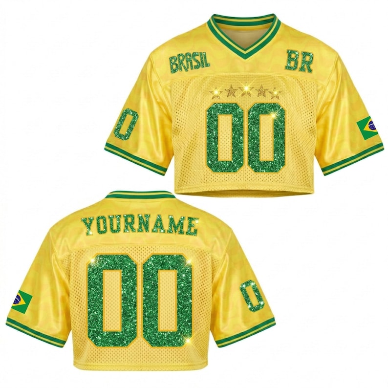 Puede incluir: Una camiseta amarilla recortada con detalles verdes, que muestra la palabra "BRASIL" y el n&uacute;mero "00" en purpurina verde. La camiseta tiene cuello en V y mangas cortas, con una bandera brasile&ntilde;a en la manga. La parte trasera de la camiseta dice "YOURNAME" y tiene el n&uacute;mero "00".