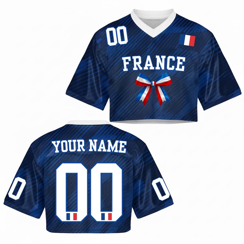 May include: A blue crop top jersey with the word "FRANCE" in white block letters, a bow in the colors of the French flag, and the number "00" in white. The back of the jersey has the text "YOUR NAME" and the number "00".