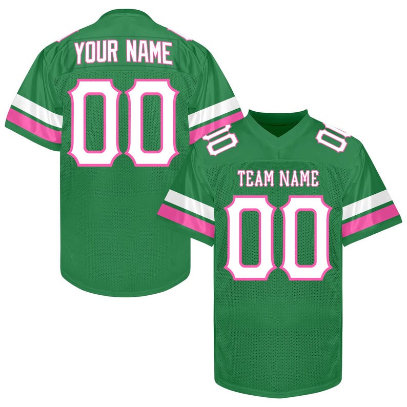 Puede incluir: Dos camisetas de f&uacute;tbol verdes con detalles blancos y rosas. Una muestra "YOUR NAME" y el n&uacute;mero "00" en blanco con contorno rosa. La otra muestra "TEAM NAME" y el n&uacute;mero "00".