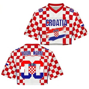 May include: Croatia-themed crop top jersey with a red and white checkered pattern. The front displays "CROATIA" in blue, along with the Croatian flag. The back features "YOUR NAME" and the number "00" in blue, with the Croatian coat of arms.