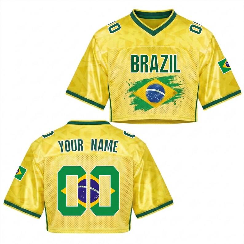 Puede incluir: Una camiseta corta amarilla con ribetes verdes y la palabra "BRAZIL" en letras verdes. La parte delantera presenta la bandera brasile&ntilde;a. La parte trasera tiene el texto "YOUR NAME" encima del n&uacute;mero "00" en verde. Una peque&ntilde;a bandera brasile&ntilde;a est&aacute; en la manga.