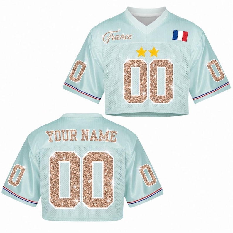 May include: Light blue crop top jersey with the word "France" in cursive and the number "00" in glitter. Features a French flag and two gold stars. The back of the jersey says "YOUR NAME" and has the number "00".