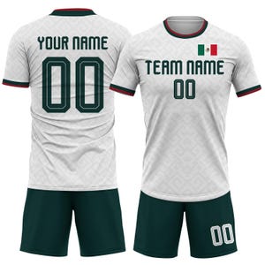 Op de afbeelding: Wit voetbalshirt en short set met groene en rode accenten. Het shirt toont de Mexicaanse vlag, de tekst "TEAM NAME" en het nummer "00". De achterkant van het shirt heeft "YOUR NAME" en het nummer "00".