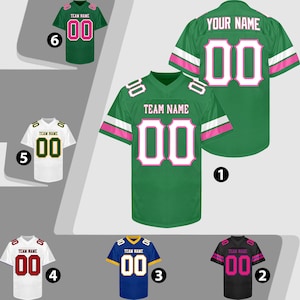 Puede incluir: Una colecci&oacute;n de camisetas de f&uacute;tbol en varios colores, incluyendo verde, blanco, azul y negro. Cada camiseta presenta el n&uacute;mero "00" en un color contrastante, con el texto "TEAM NAME" o "YOUR NAME" arriba. Las camisetas tienen diferentes combinaciones de colores.