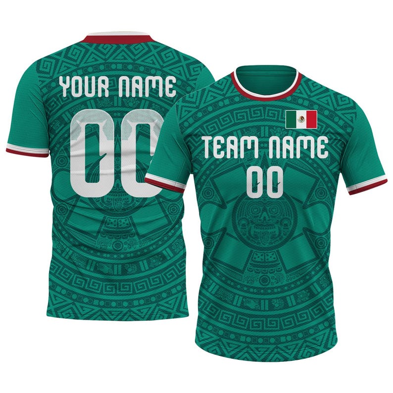 Op de afbeelding: Twee groene voetbalshirts met witte letters en het nummer 00. E&eacute;n shirt heeft "YOUR NAME" op de rug, de andere heeft "TEAM NAME". Beide hebben een Mexicaanse vlag en door Azteken ge&iuml;nspireerde patronen. De shirts hebben rode en witte afwerking.