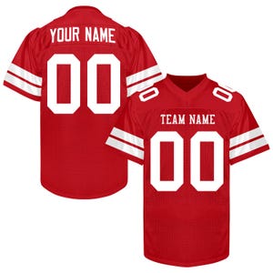 Puede incluir: Dos camisetas de f&uacute;tbol americano rojas con detalles blancos. Una camiseta tiene "YOUR NAME" y el n&uacute;mero "00" en la espalda. La otra tiene "TEAM NAME" y el n&uacute;mero "00" en la parte delantera.